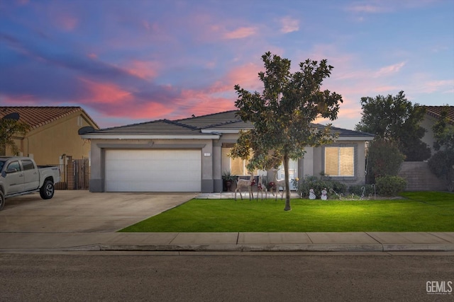 view of front of home with a yard and a garage