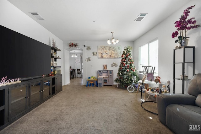 carpeted living room with a chandelier