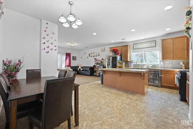 kitchen with pendant lighting, a chandelier, stainless steel appliances, beverage cooler, and a kitchen breakfast bar