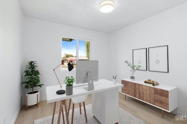 office space with light hardwood / wood-style floors and a textured ceiling