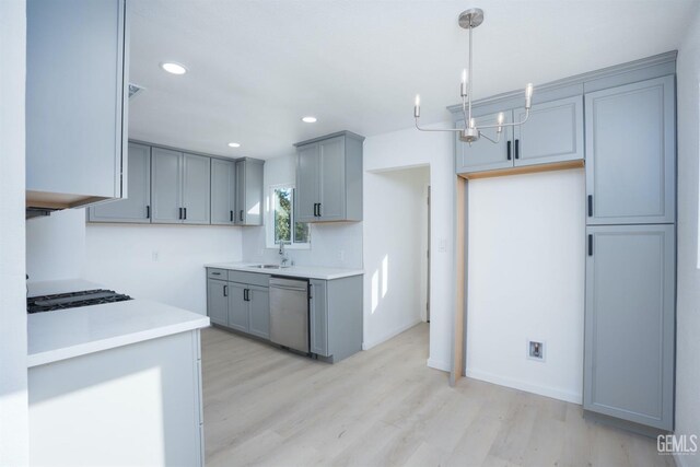 kitchen with pendant lighting, sink, appliances with stainless steel finishes, gray cabinetry, and light wood-type flooring