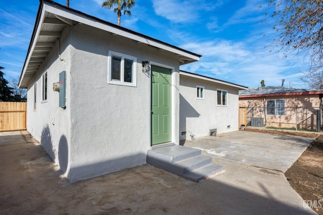 rear view of property with central AC unit and a patio