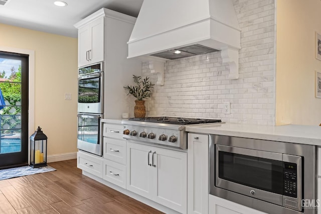 401 Via Carisma, Bakersfield, CA 93309 - kitchen with stainless steel appliances, custom range hood, light countertops, backsplash, and white cabinets