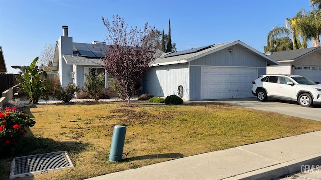 single story home with a garage, a front yard, and solar panels