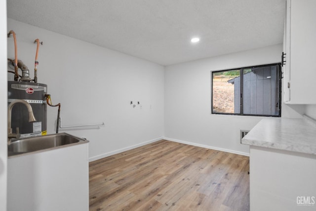 24501 Pueblo Ct, Tehachapi, CA 93561 - unfurnished dining area featuring gas water heater, light wood-style floors, recessed lighting, and a textured ceiling