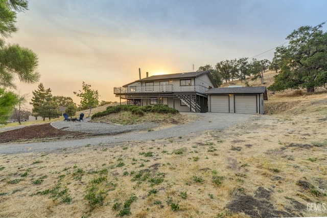 24501 Pueblo Ct, Tehachapi, CA 93561 - view of front facade featuring stairway, a wooden deck, a garage, and gravel driveway