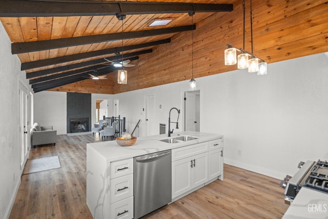 24501 Pueblo Ct, Tehachapi, CA 93561 - kitchen with stainless steel appliances, a ceiling fan, white cabinets, open floor plan, and a fireplace