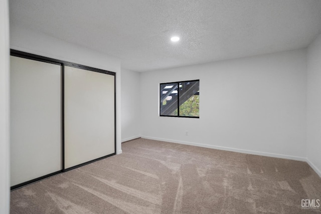 24501 Pueblo Ct, Tehachapi, CA 93561 - unfurnished bedroom featuring carpet floors, a closet, a textured ceiling, and recessed lighting