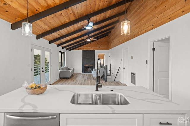 24501 Pueblo Ct, Tehachapi, CA 93561 - kitchen with stainless steel dishwasher, a wood ceiling with exposed beams, open floor plan, light stone counters, and wood finished floors
