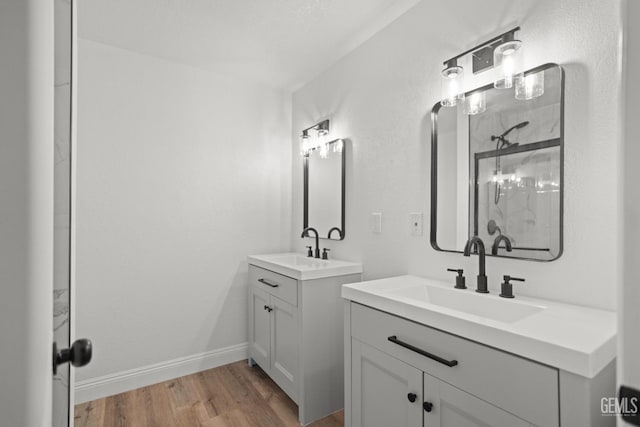 24501 Pueblo Ct, Tehachapi, CA 93561 - bathroom featuring wood finished floors, two vanities, and a shower