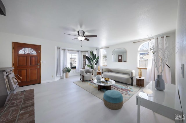 living room with a ceiling fan and baseboards