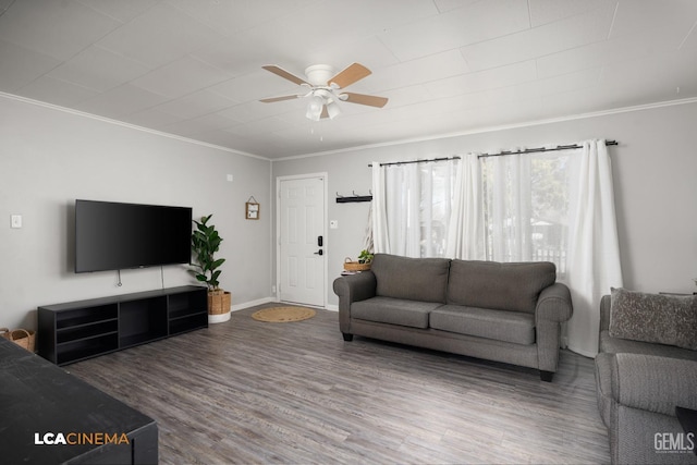 living room with wood-type flooring, ornamental molding, and ceiling fan