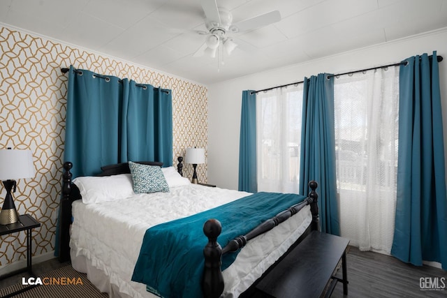 bedroom featuring crown molding, dark wood-type flooring, and ceiling fan