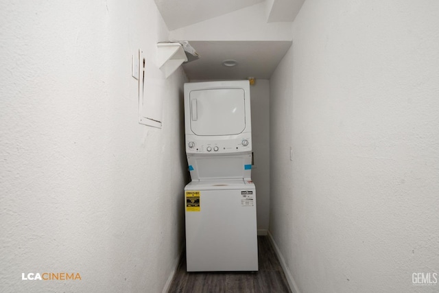 washroom with stacked washer and clothes dryer and dark wood-type flooring