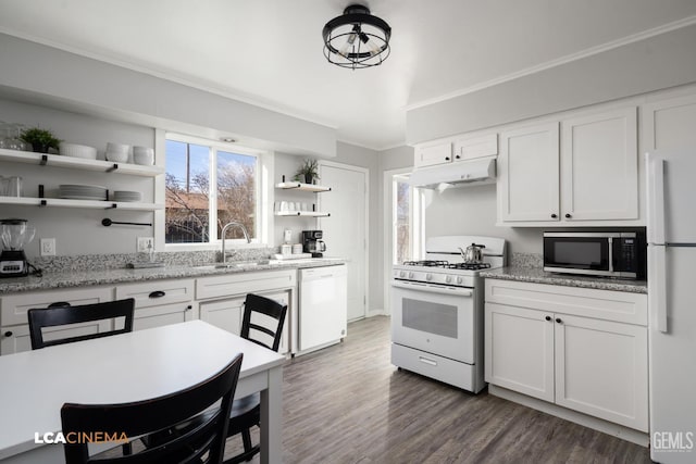 kitchen featuring sink, white cabinets, ornamental molding, light stone counters, and white appliances