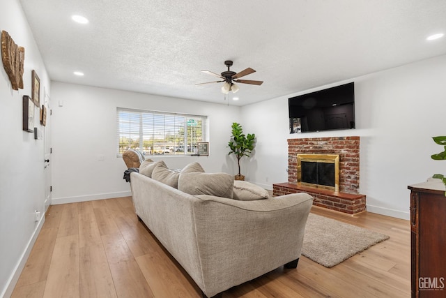 6101 Crestmore St, Bakersfield, CA 93308 - living area with a ceiling fan, light wood finished floors, recessed lighting, a brick fireplace, and a textured ceiling
