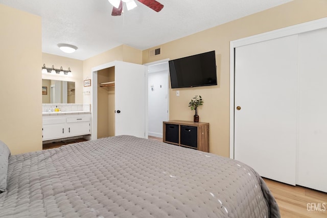 6101 Crestmore St, Bakersfield, CA 93308 - bedroom with wood finished floors, ensuite bathroom, a textured ceiling, and ceiling fan