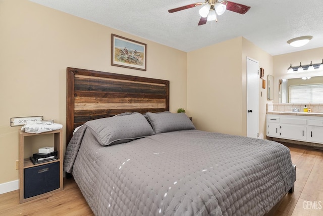 6101 Crestmore St, Bakersfield, CA 93308 - bedroom with light wood finished floors, a textured ceiling, ensuite bath, and ceiling fan