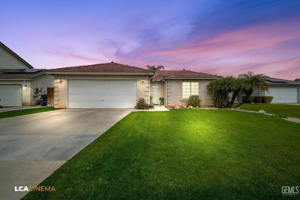 ranch-style home with a yard and a garage