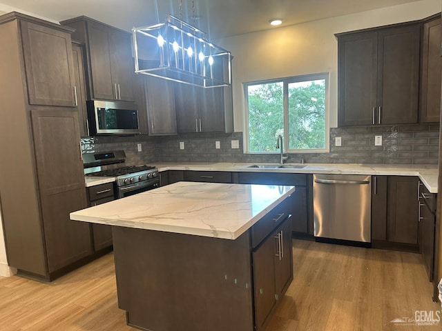 18671 Buckeye Pl, Tehachapi, CA 93561 - kitchen with stainless steel appliances, light wood-style floors, backsplash, a center island, and recessed lighting