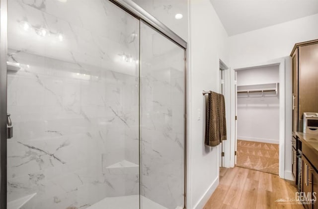 18671 Buckeye Pl, Tehachapi, CA 93561 - bathroom with a marble finish shower, wood finished floors, a walk in closet, and vanity