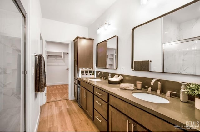 18671 Buckeye Pl, Tehachapi, CA 93561 - bathroom with double vanity, a walk in closet, wood finished floors, and a stall shower