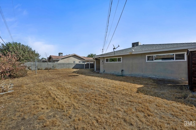 rear view of house featuring a yard