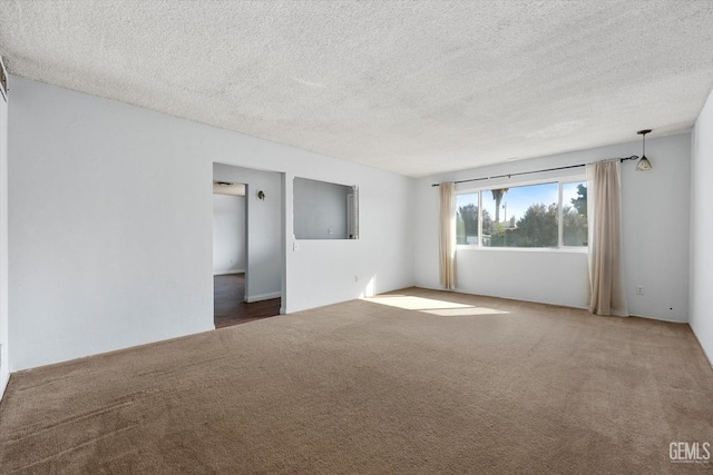 carpeted spare room with a textured ceiling