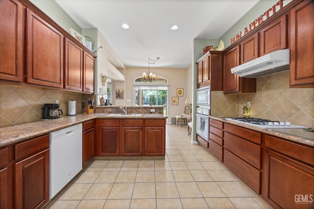 9005 Via Lugano, Bakersfield, CA 93312 - kitchen featuring white appliances, under cabinet range hood, decorative backsplash, a chandelier, and recessed lighting