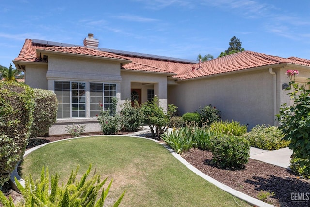 10400 Walnut Creek Ct, Bakersfield, CA 93311 - mediterranean / spanish-style home with stucco siding, roof mounted solar panels, a chimney, a front lawn, and a tile roof