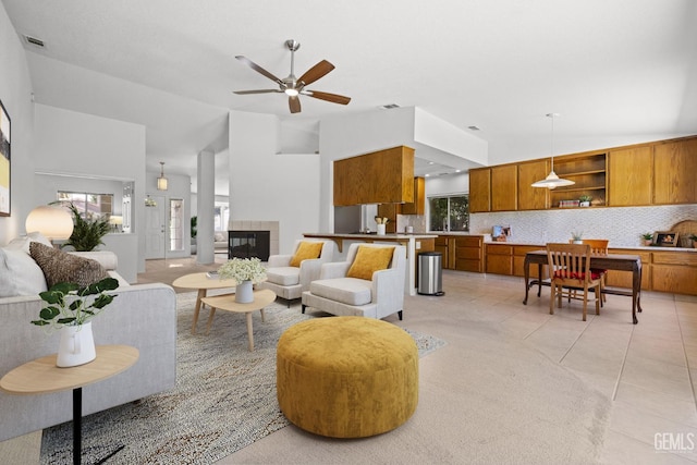 10400 Walnut Creek Ct, Bakersfield, CA 93311 - living room with a ceiling fan, light tile patterned flooring, a tiled fireplace, and high vaulted ceiling