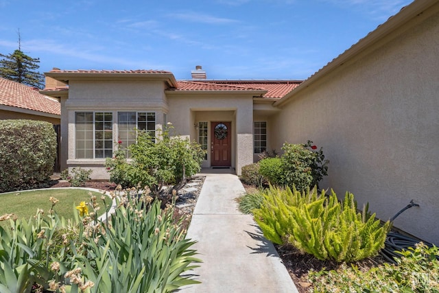 10400 Walnut Creek Ct, Bakersfield, CA 93311 - property entrance with stucco siding, a tiled roof, and a chimney