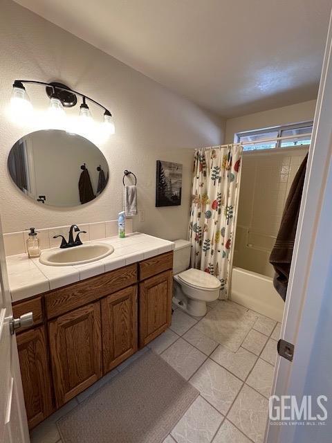 full bathroom with tile patterned flooring, vanity, toilet, and shower / bathtub combination with curtain