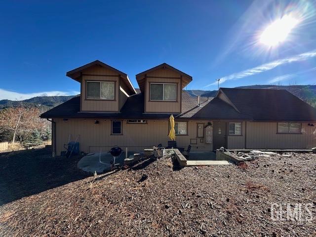 rear view of property featuring a mountain view and a patio area