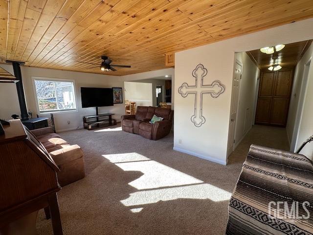 carpeted living room with ceiling fan and wooden ceiling