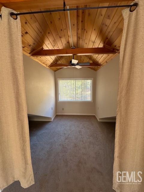 carpeted empty room featuring lofted ceiling with beams, ceiling fan, and wooden ceiling