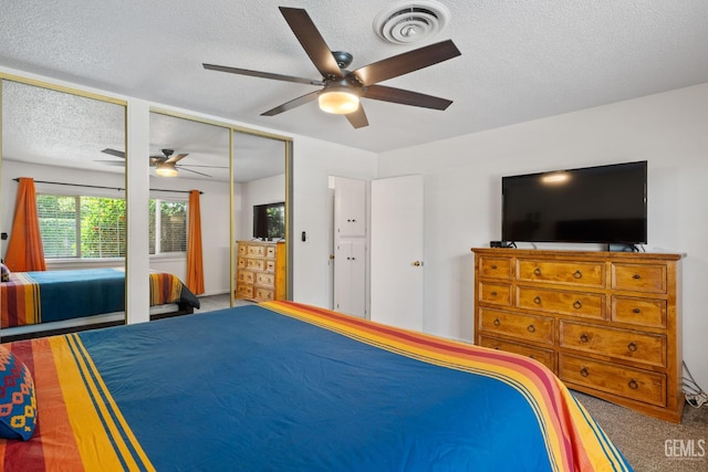 2924 Elm St, Bakersfield, CA 93301 - bedroom with carpet floors, a textured ceiling, a ceiling fan, and two closets