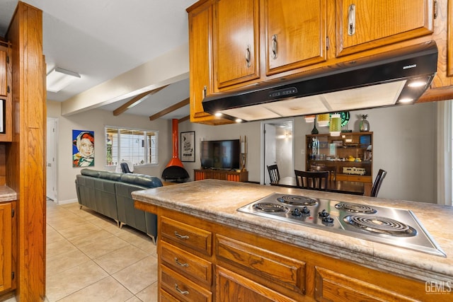 2924 Elm St, Bakersfield, CA 93301 - kitchen with under cabinet range hood, brown cabinets, stainless steel electric stovetop, light tile patterned floors, and light countertops