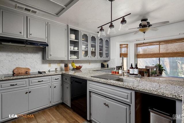 kitchen with visible vents, black appliances, under cabinet range hood, a sink, and wood finished floors