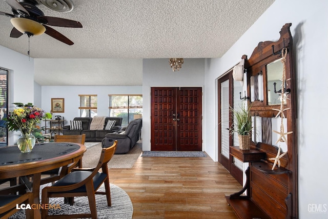 foyer entrance with a ceiling fan, wood finished floors, and a textured ceiling