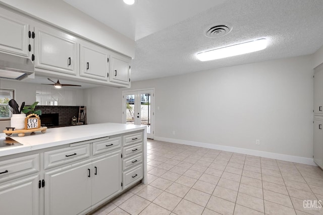 kitchen with light tile patterned floors, visible vents, light countertops, french doors, and white cabinetry