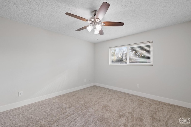 empty room featuring a textured ceiling, carpet, a ceiling fan, and baseboards