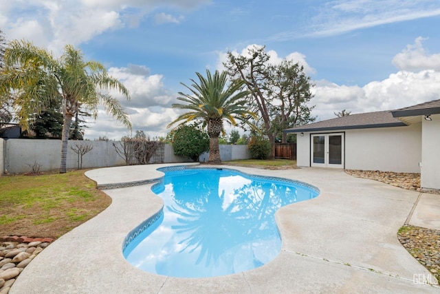 view of pool with french doors, a patio area, and a fenced backyard