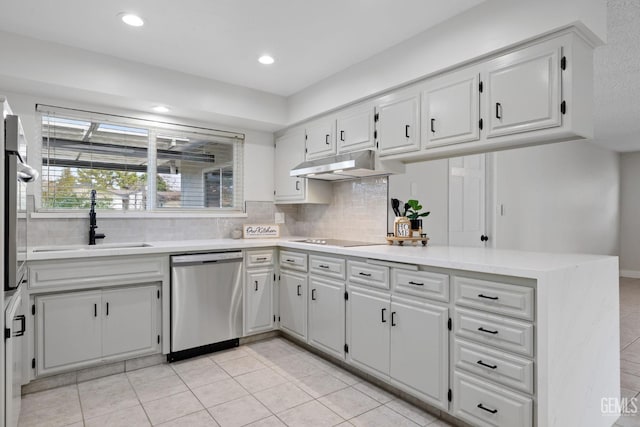 kitchen with white cabinets, light countertops, under cabinet range hood, and stainless steel dishwasher