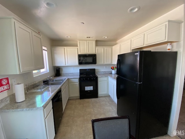 kitchen with white cabinets, black appliances, and light countertops