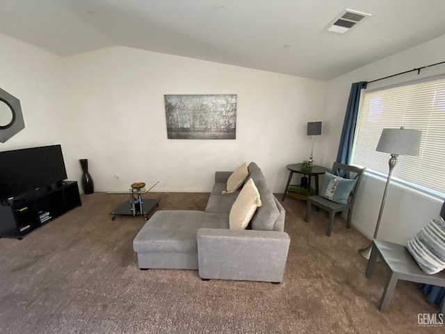 living area with carpet, visible vents, and lofted ceiling
