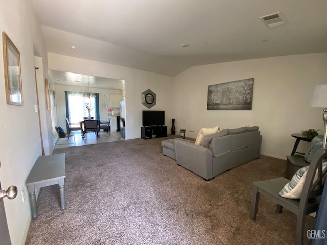 carpeted living area featuring visible vents, a chandelier, and lofted ceiling