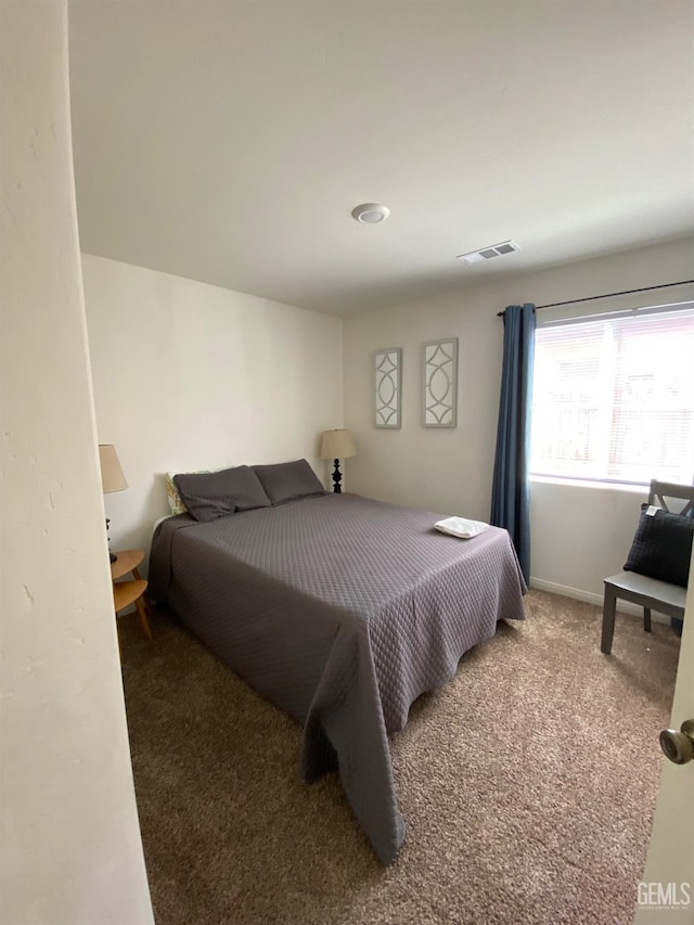 bedroom featuring baseboards, visible vents, and carpet