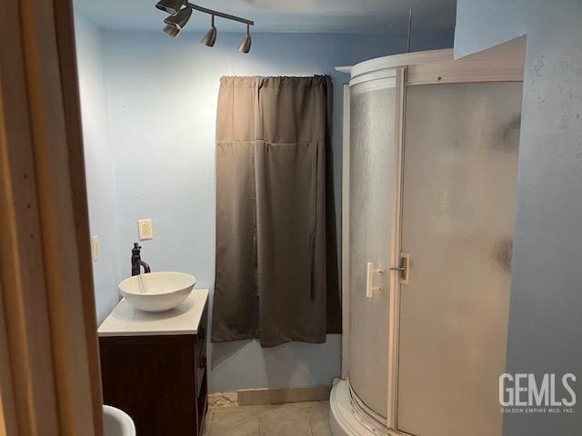 bathroom with a shower with door and vanity