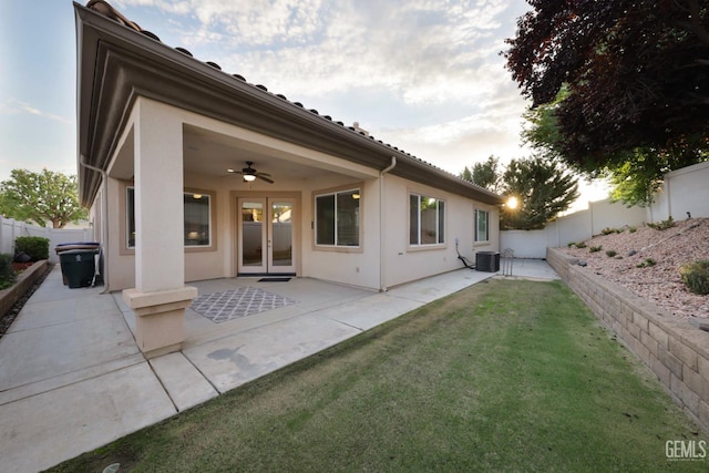 back of house featuring central air condition unit, a patio area, ceiling fan, and a lawn